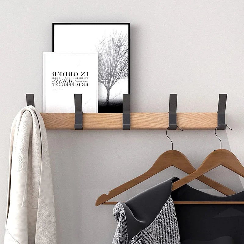 Wall rack holding clothes on hangers and a small shelf on top