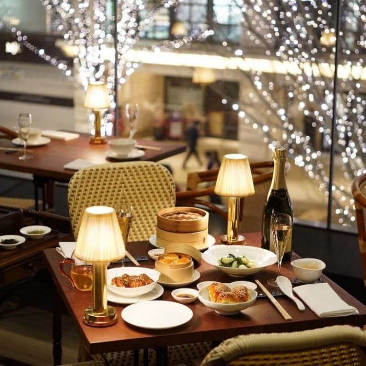 Gold cordless rechargeable touch table lamps lit on restaurant tables in the evening