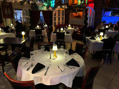 Gold cordless rechargeable touch table lamps lit across tables in a warm restaurant interior
