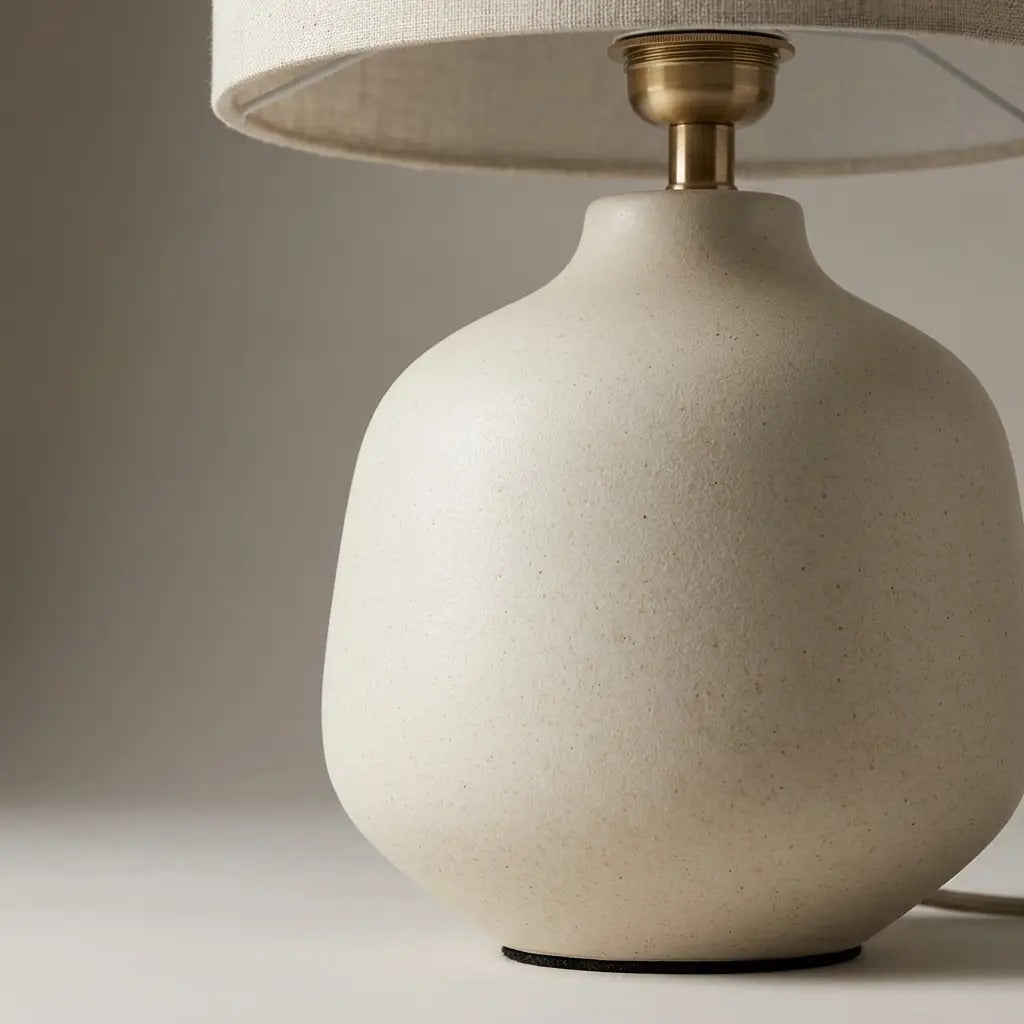 Ivory ceramic table lamp lit in a calm interior setting