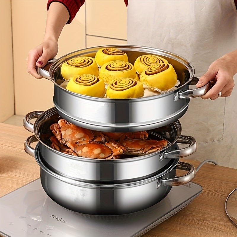 Hands lifting the top tier with buns above a tier of crab on an induction hob