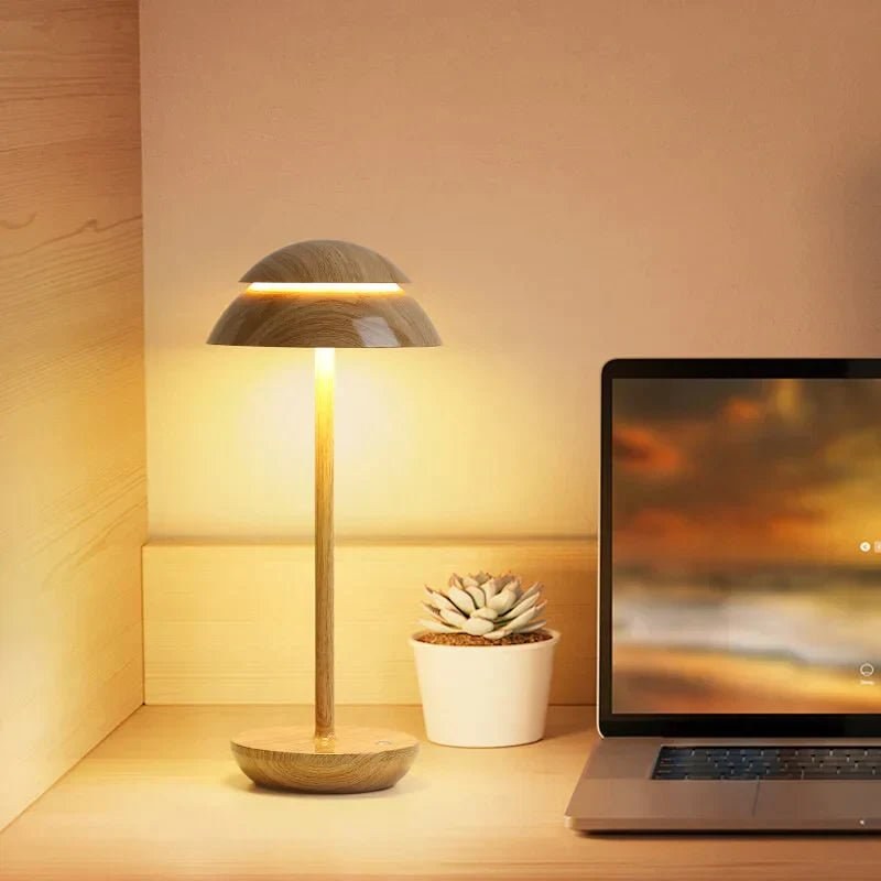 Wood cordless dome table lamp on a desk beside a laptop