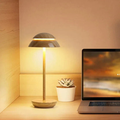 Wood cordless dome table lamp on a desk beside a laptop