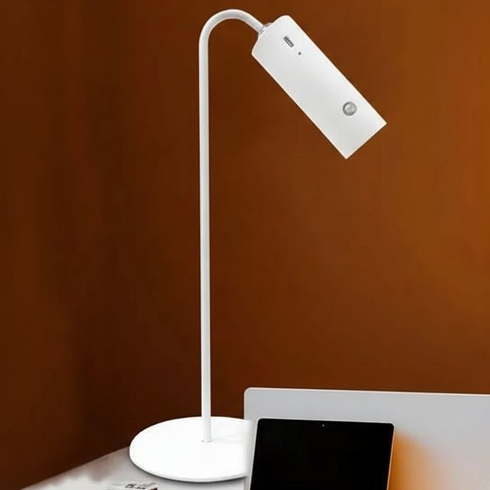 White desk lamp beside a laptop