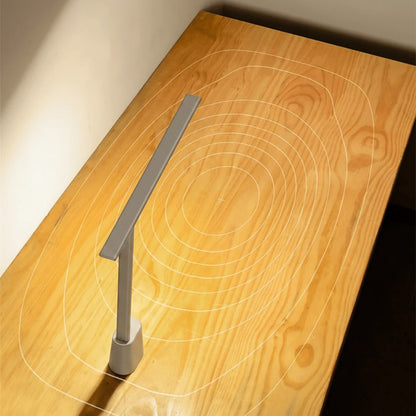 Foldable slim LED desk lamp lighting a wooden desk