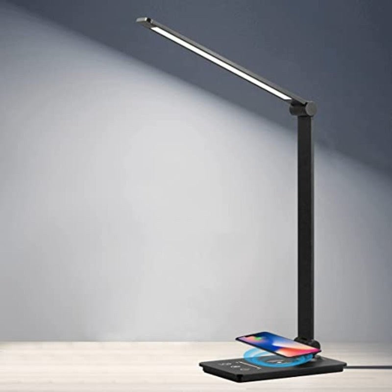 LED desk lamp charging a phone on its base