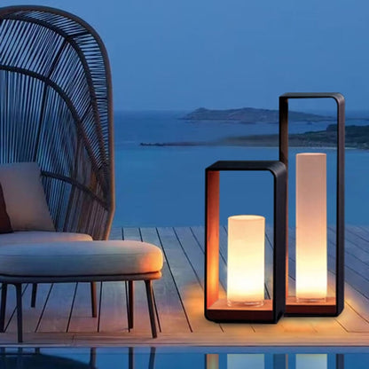 Two solar lanterns glowing on a wooden deck by the sea at dusk