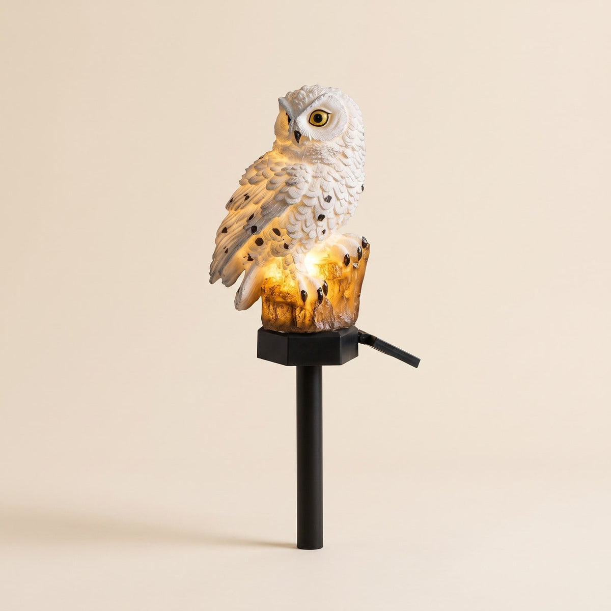 White solar owl garden stake light with a warm glowing tree stump