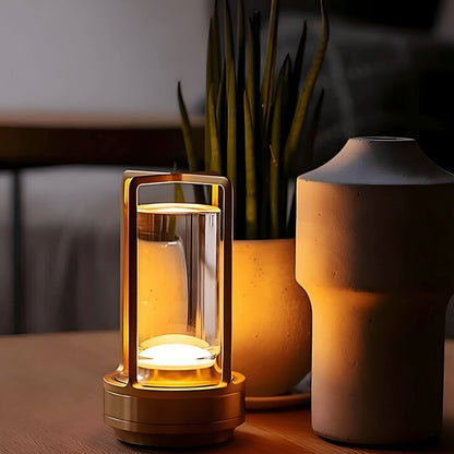 Gold lantern table lamp beside a plant and vase