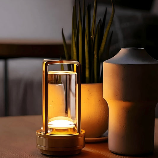 Gold lantern table lamp beside a plant and vase