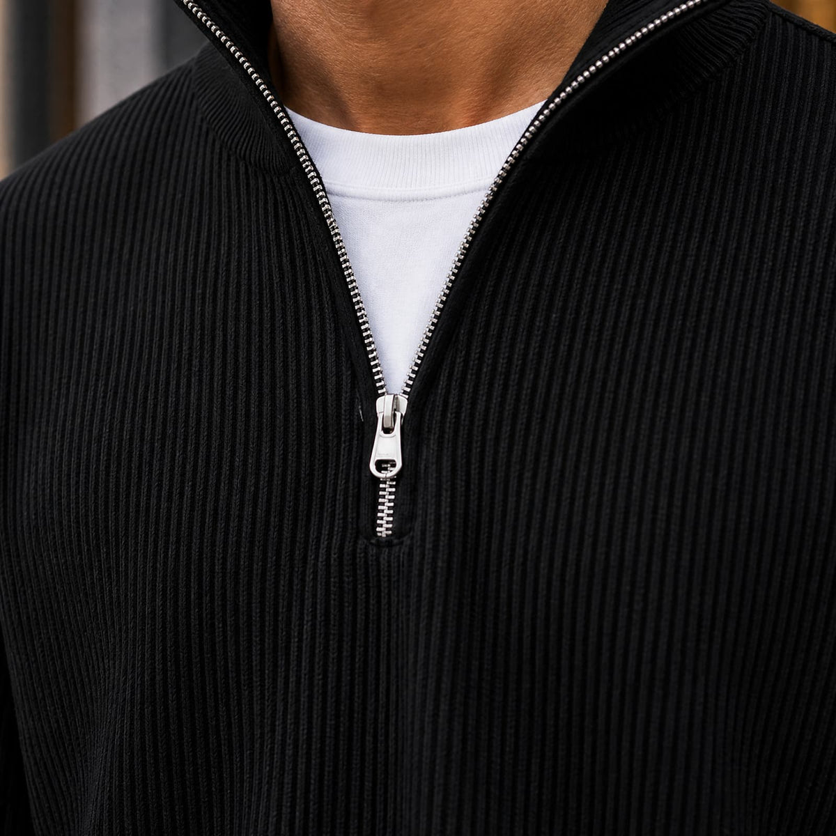 Close-up of the black ribbed knit and metal quarter zip