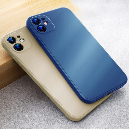Blue and sand silicone phone cases lying on a wooden table edge