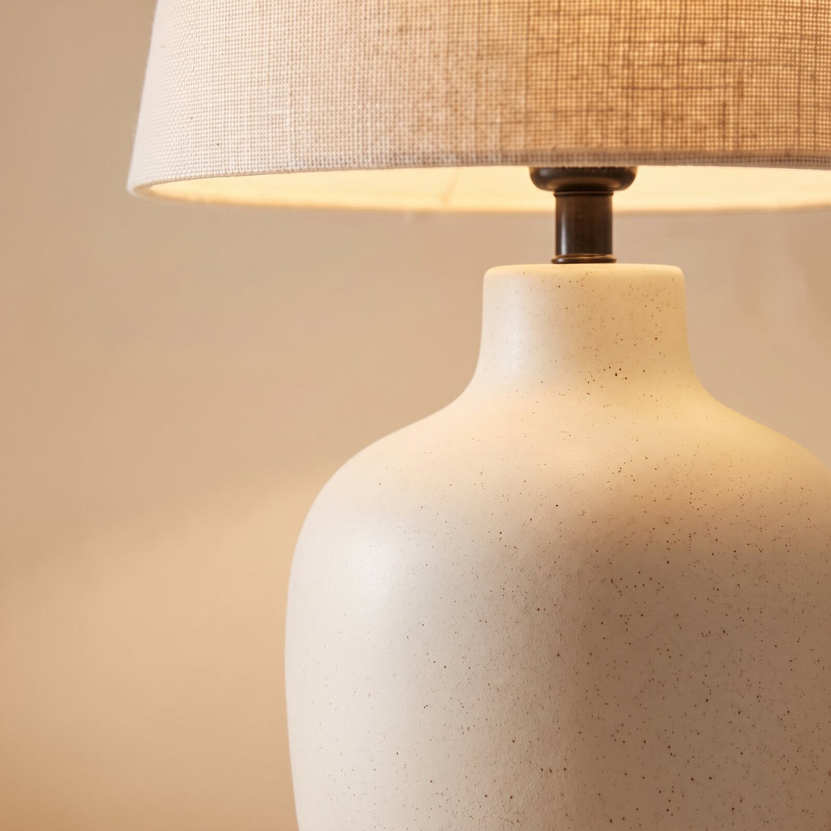 Close-up of the speckled ivory ceramic base and linen shade