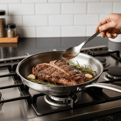 Searing steak in the stainless steel pan on a gas hob
