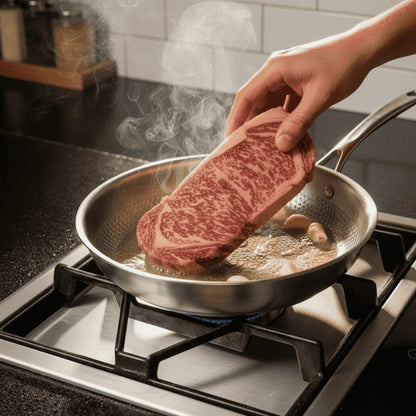 Placing a steak in the hot stainless steel pan