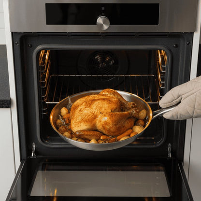 Stainless steel pan with roast chicken in the oven