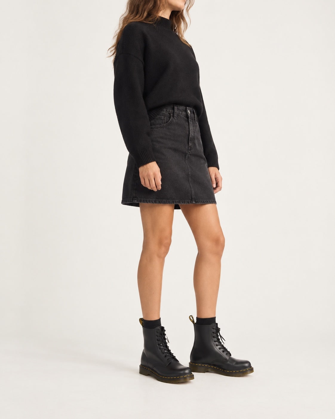 Woman wearing black lace-up boots with a skirt