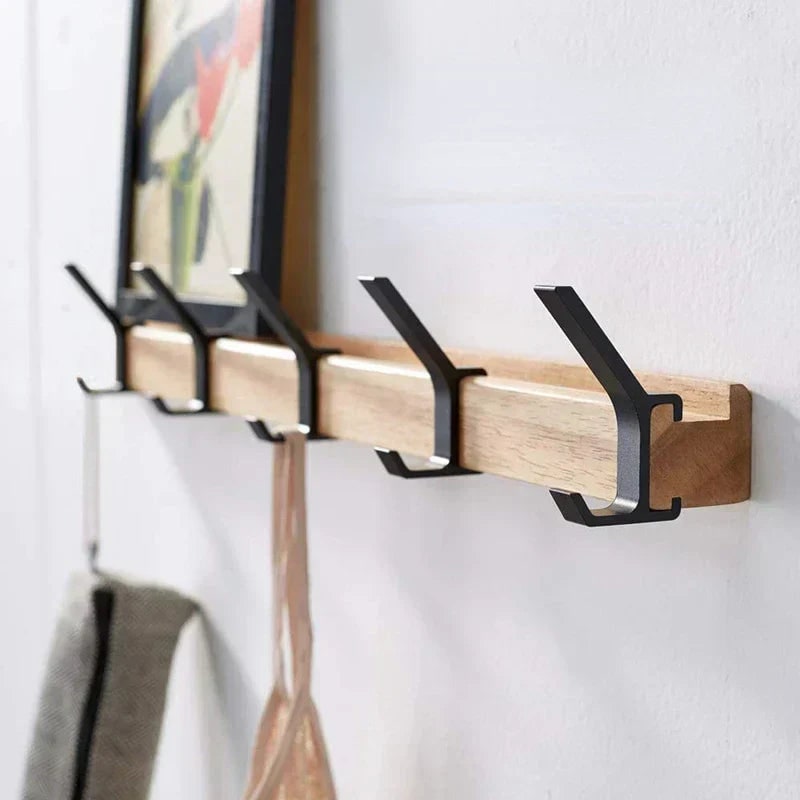 Wall rack with a towel and a top hanging on the hooks