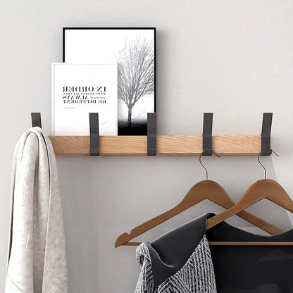 Wall rack holding clothes on hangers and a small shelf on top