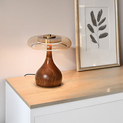 Glass disc LED table lamp on a white cabinet