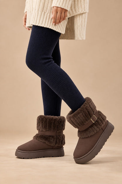 Coffee fur-trimmed snow boots worn with leggings