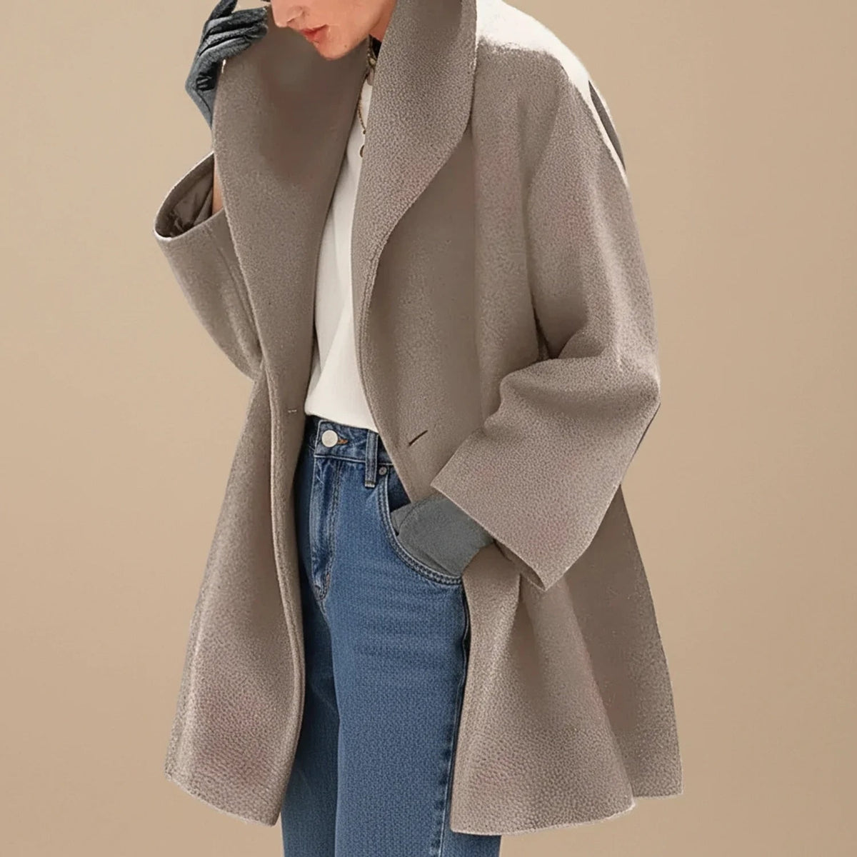 Woman wearing a taupe oversized A-line coat with a wide collar