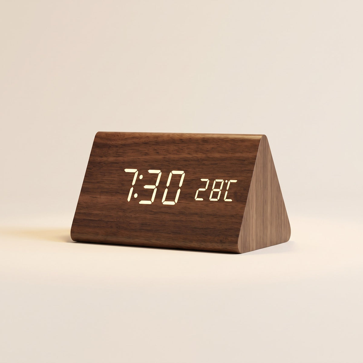 Brown wooden triangle LED desk clock on a cream background
